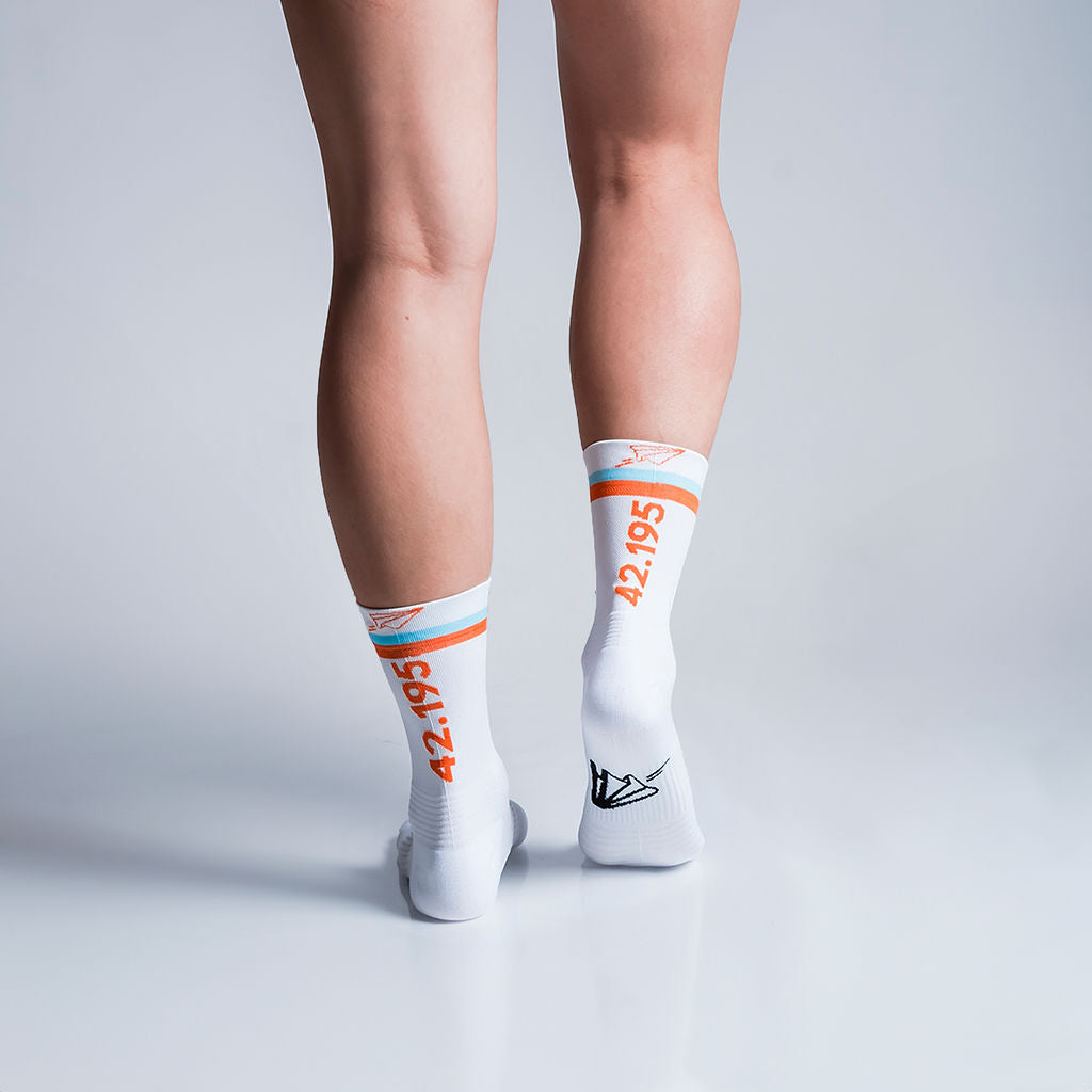 Calcetas deportivas 42.195 para running, maratón y ciclismo. Con diseño técnico transpirable, compresión media y soporte en arco plantar, costura antiampollas.